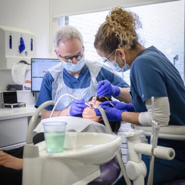 patient being treated by specialist dentist and dental nurse